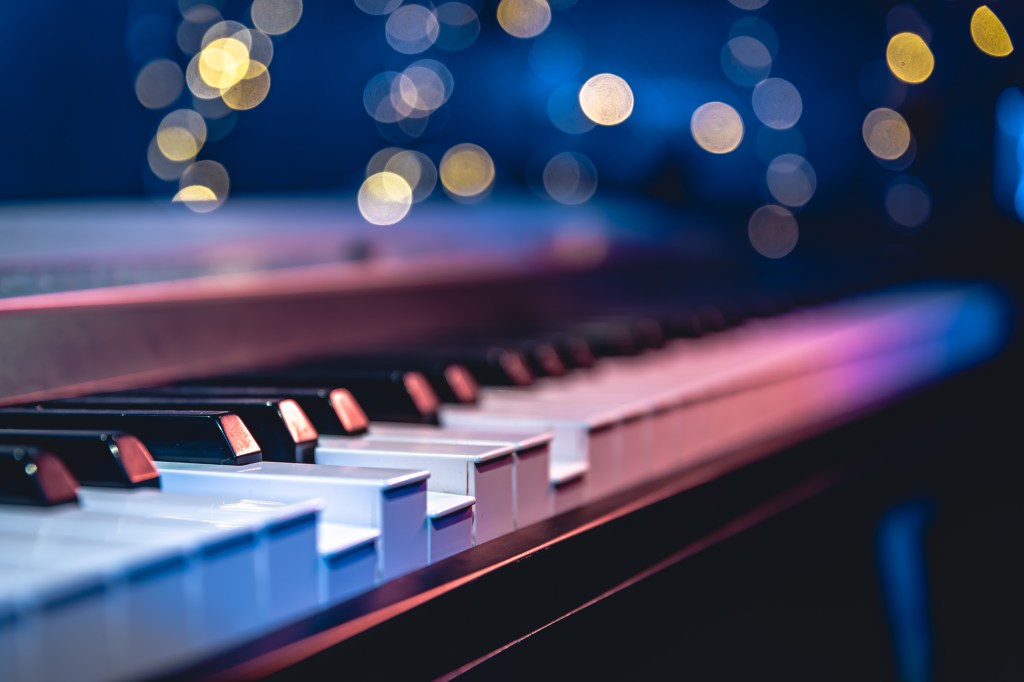 A piano keyboard with light specks in the background